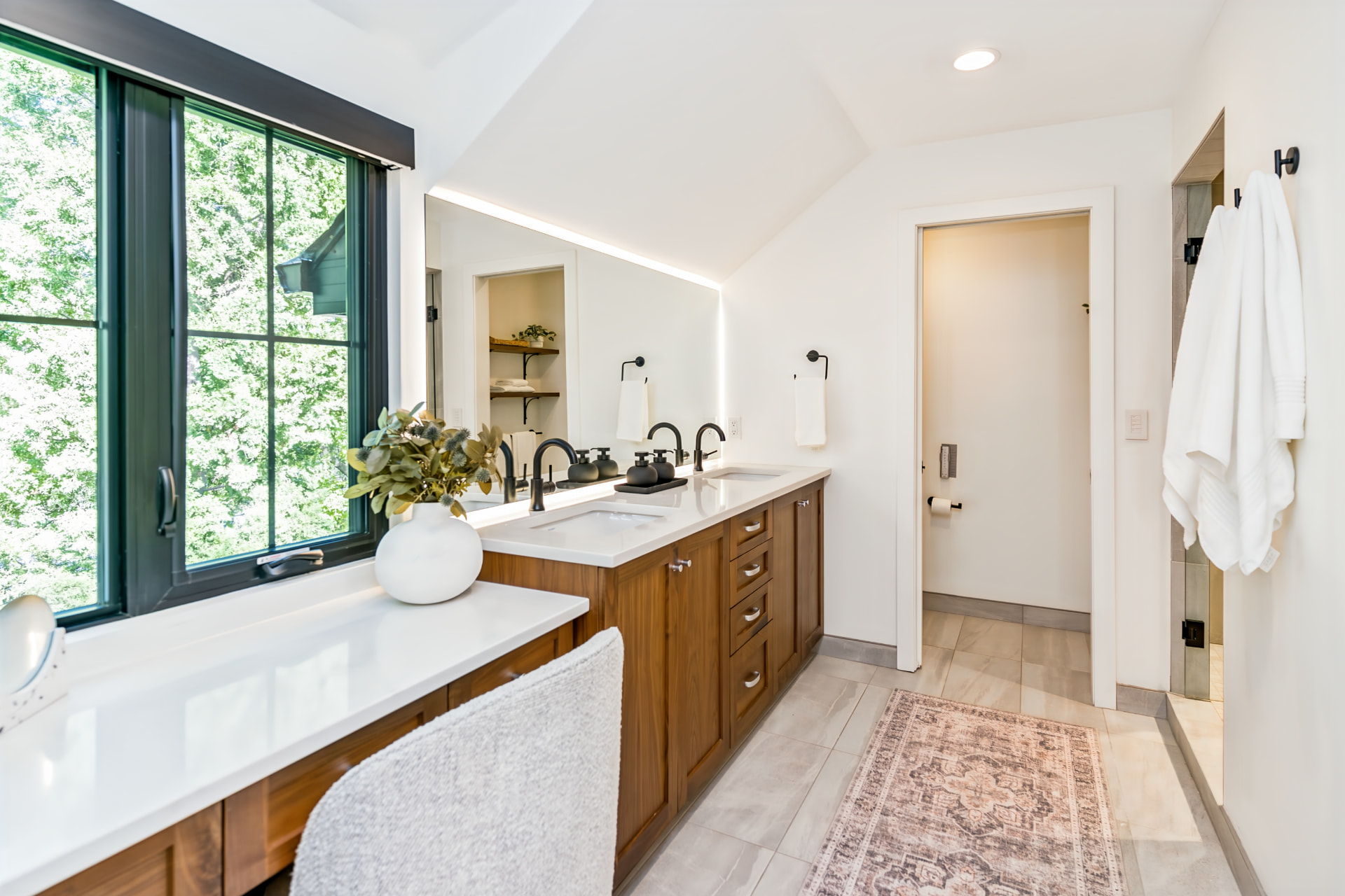 Primary ensuite with custom double vanity, treetop views and heated tile floor