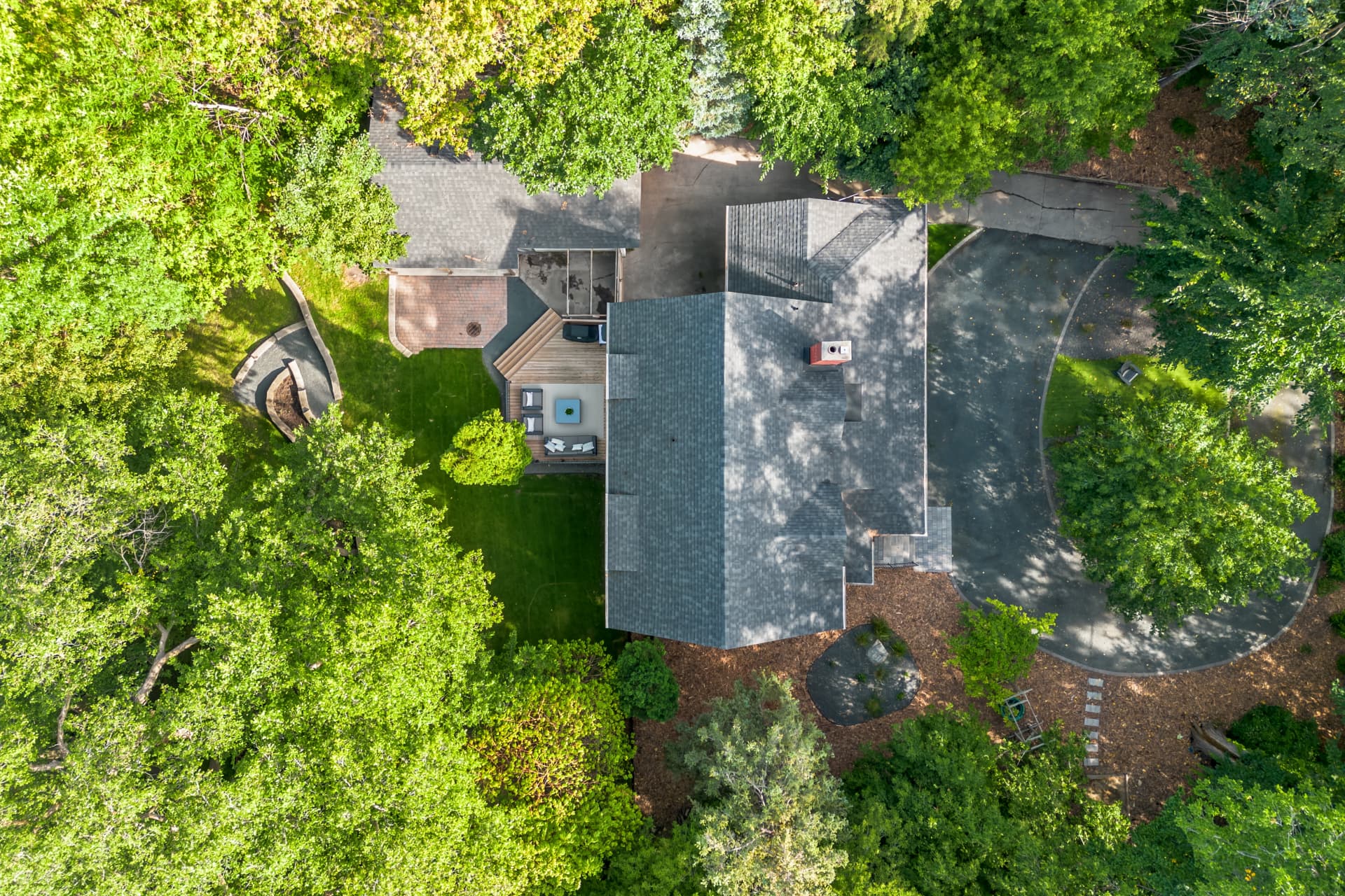 Aerial view of the house, deck and wooded lot