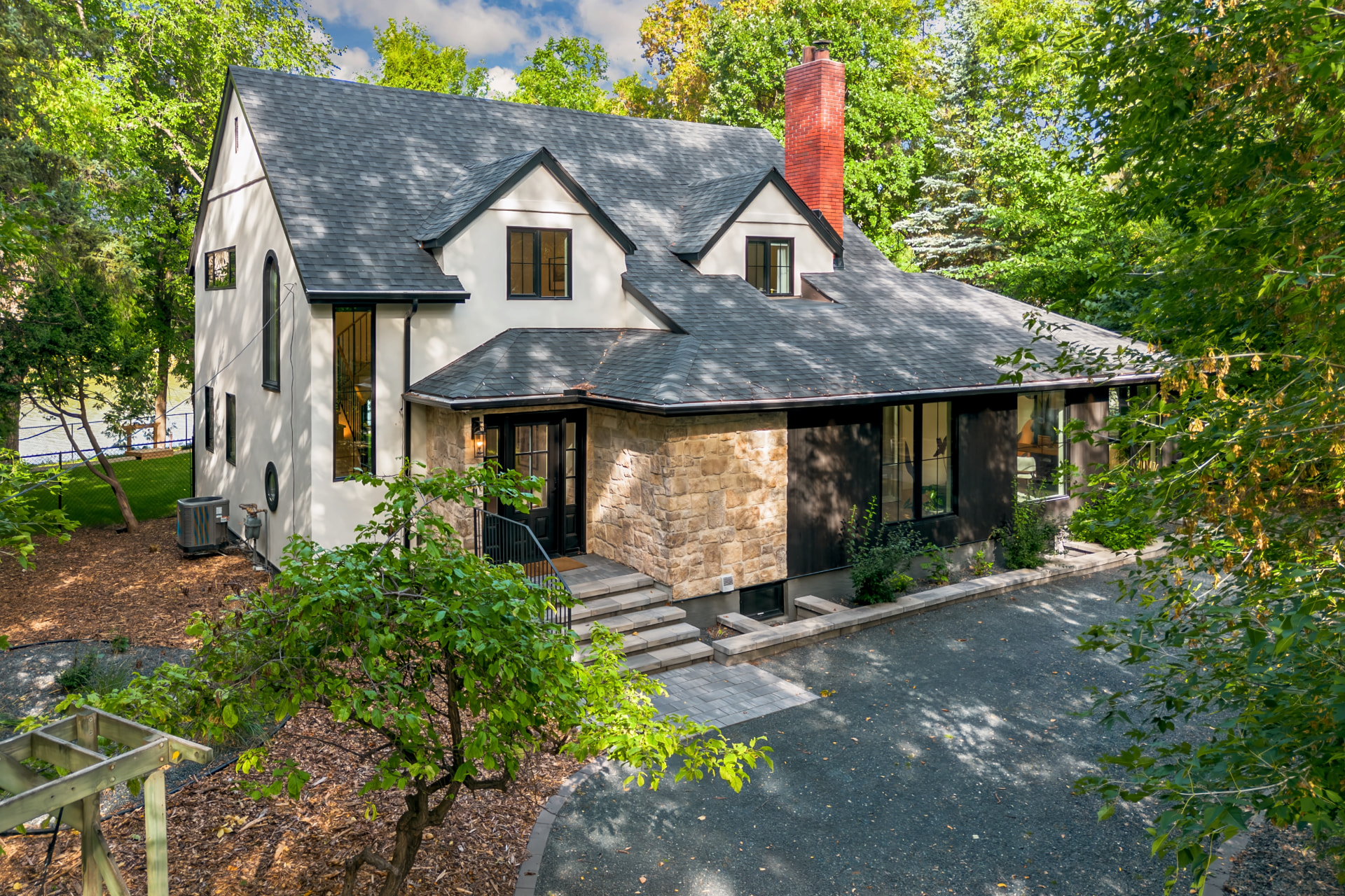 409 North Drive exterior with stone, stucco, mature trees and a circular driveway