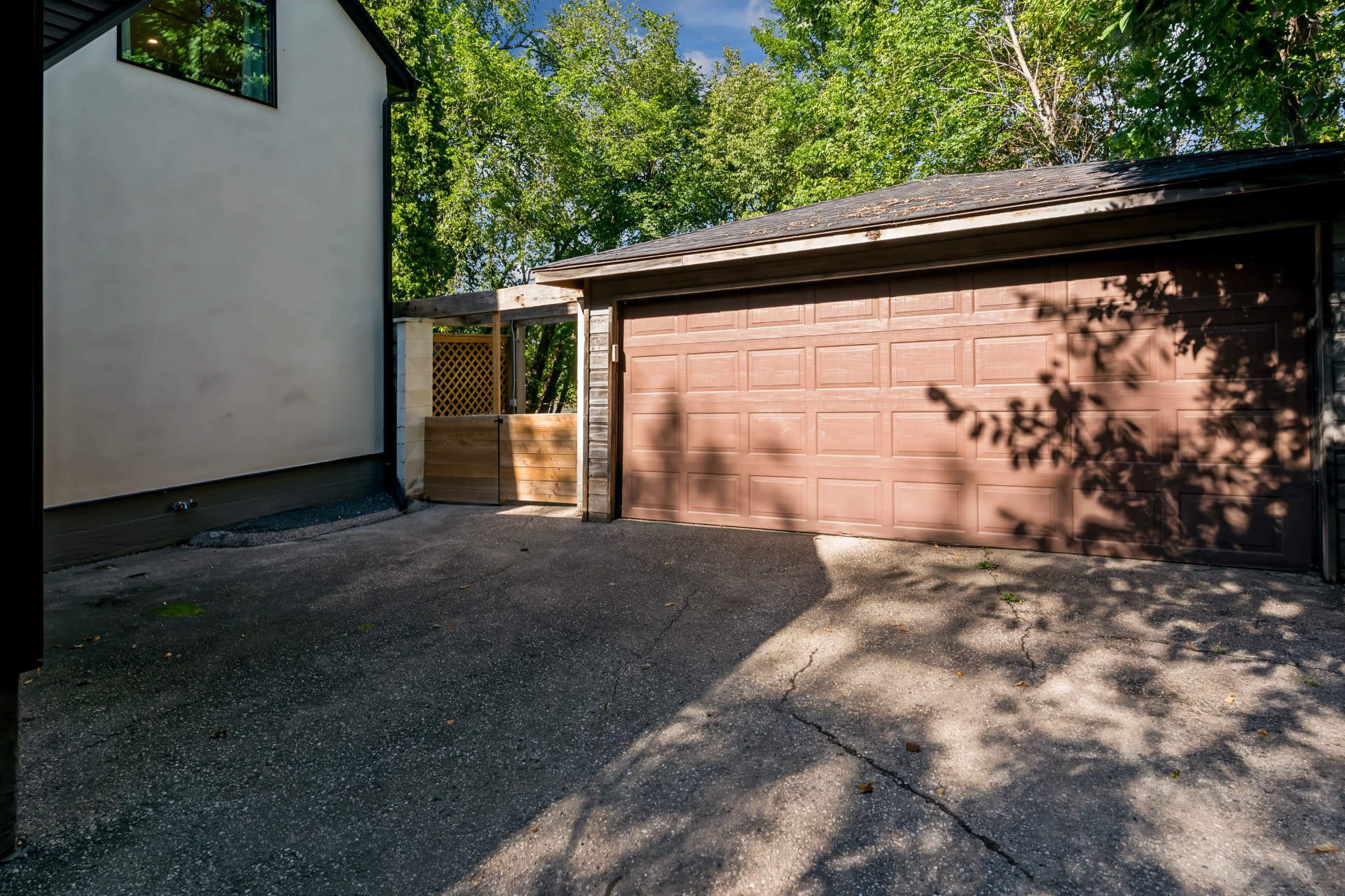 Detached double garage with paved parking beside the house