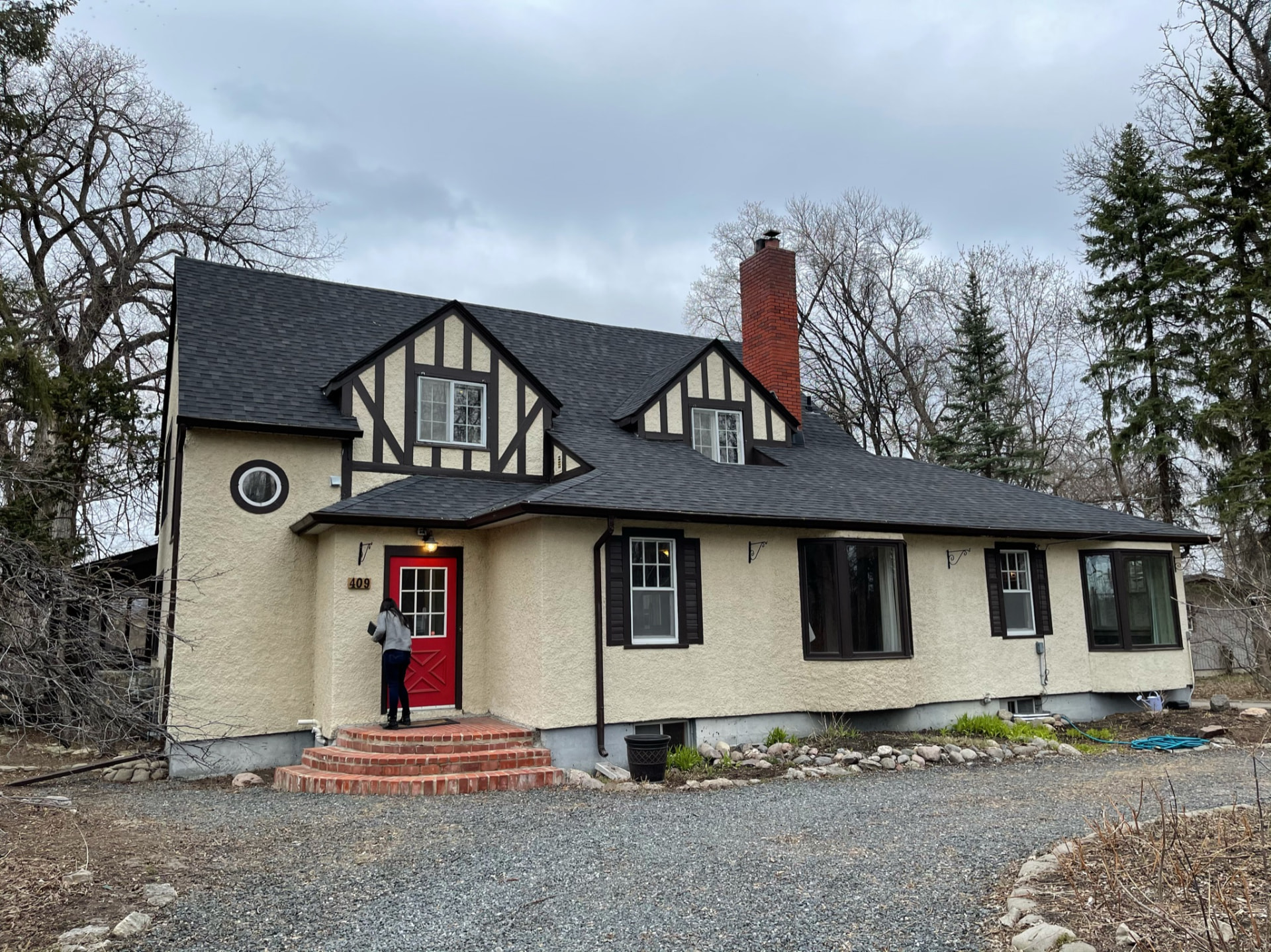 Original Tudor-style exterior with red front door before the renovation