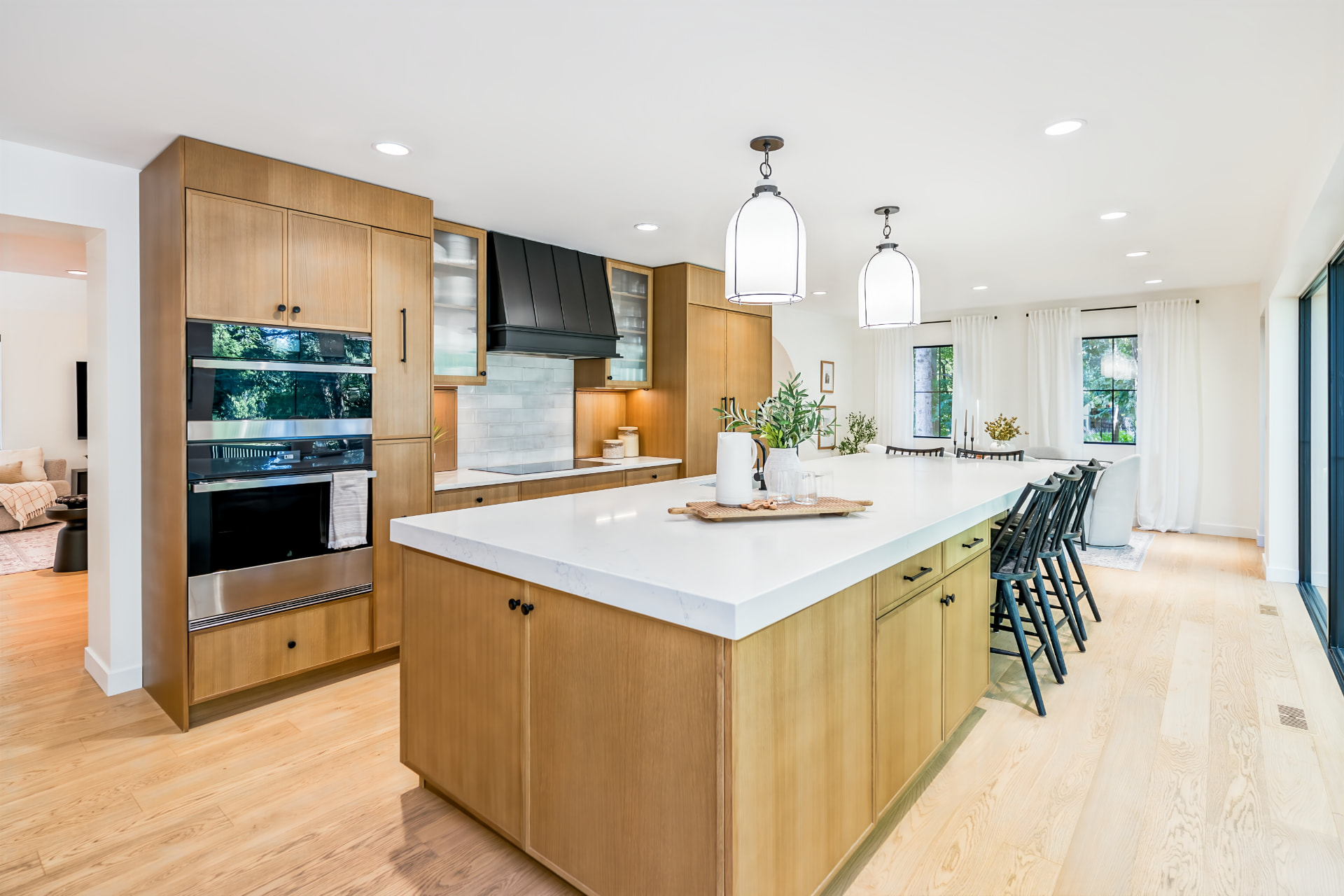 Custom oak kitchen with oversized quartz island and adjoining dining area