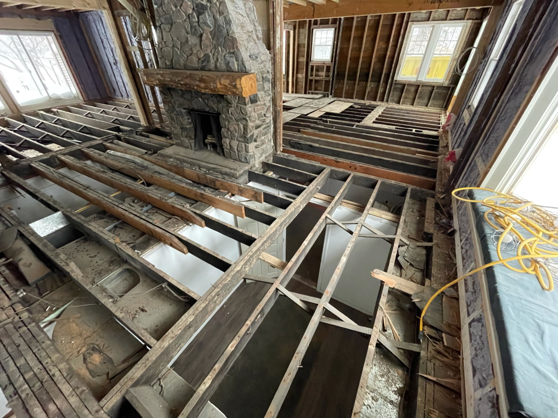 Living room stripped to the studs with floor joists exposed