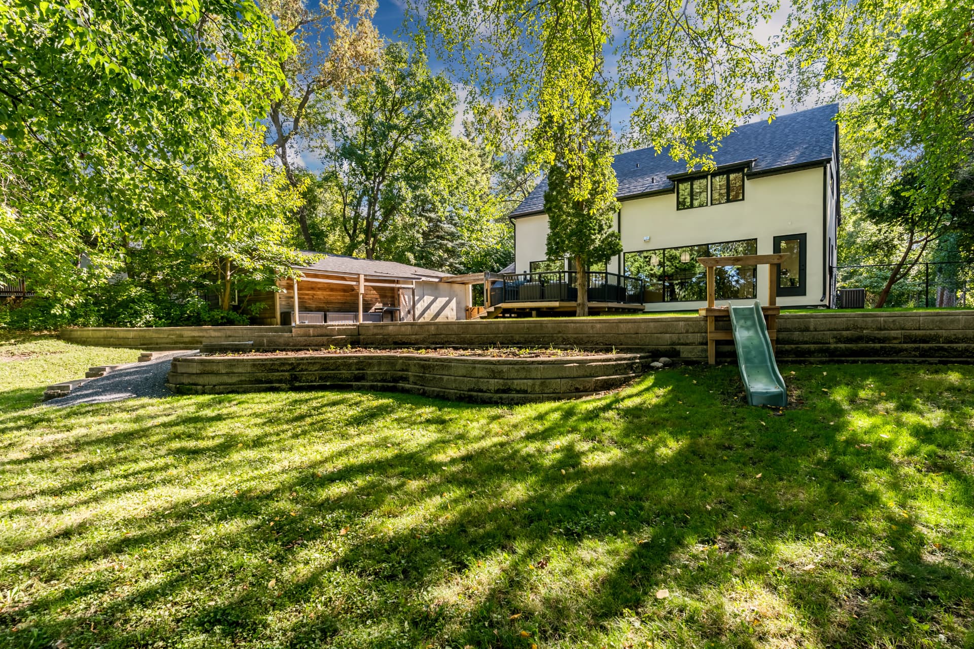 Rear elevation of the home with terraced retaining walls and lawn
