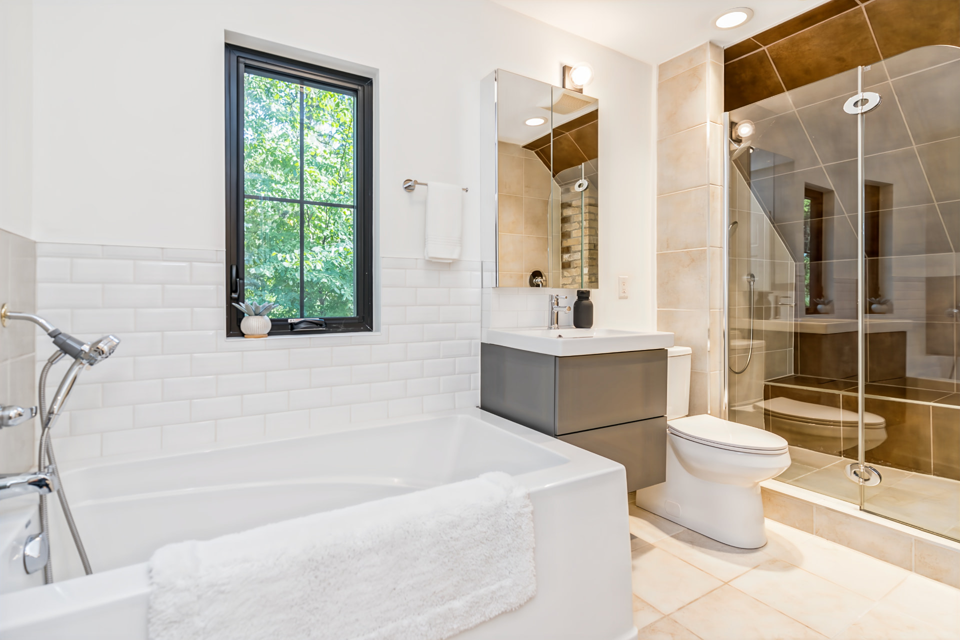 Upstairs bathroom with soaker tub, glass shower and exposed brick